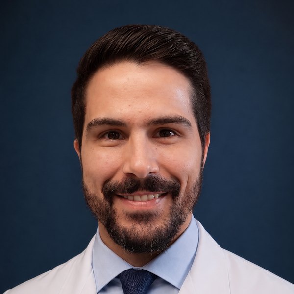 Dr. Matheus Goebel, médico pneumologista, de jaleco branco e gravata, sorrindo